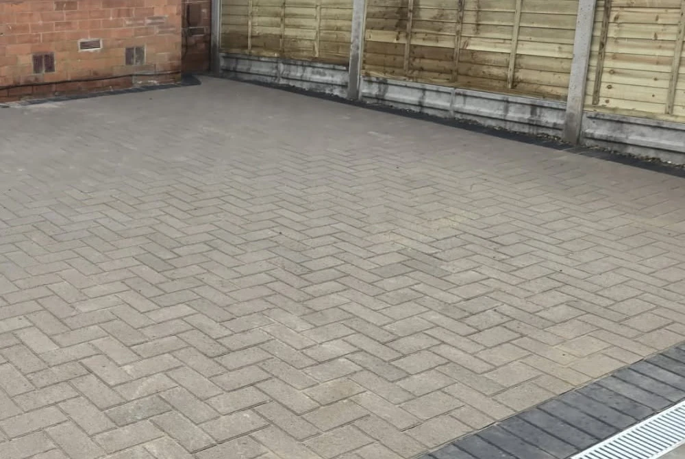 Light block-paved driveway and timber boundary fence by Boothville Services.