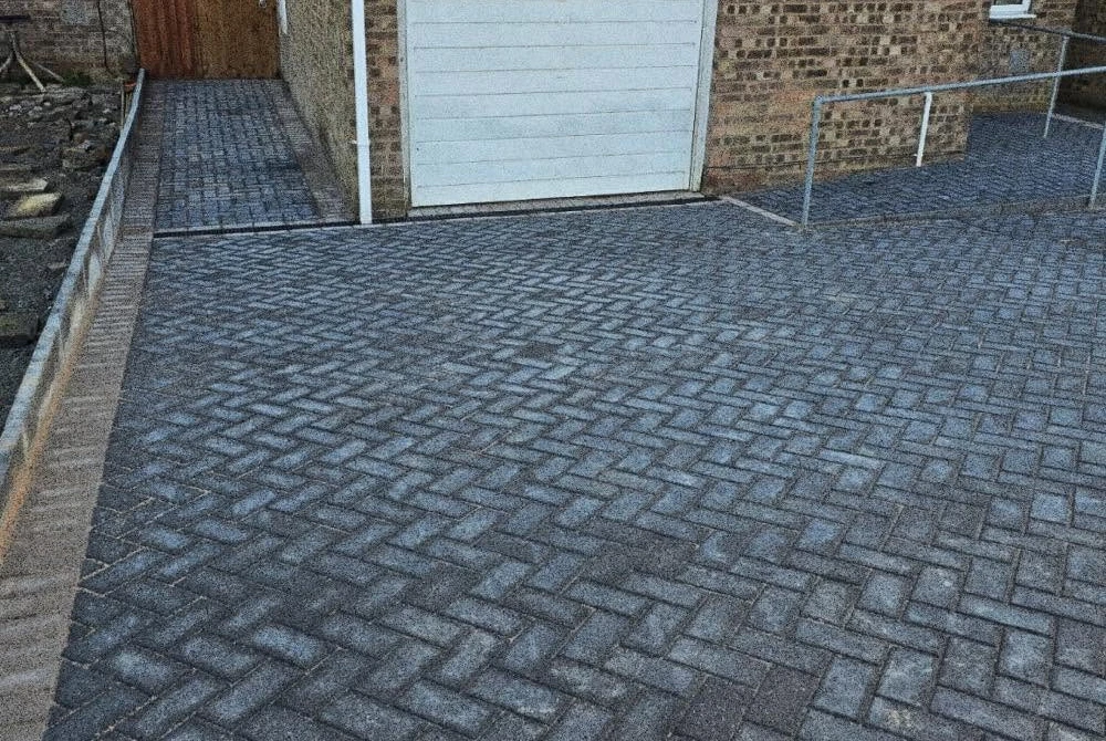 Dark block-paved garage frontage by Boothville Services.