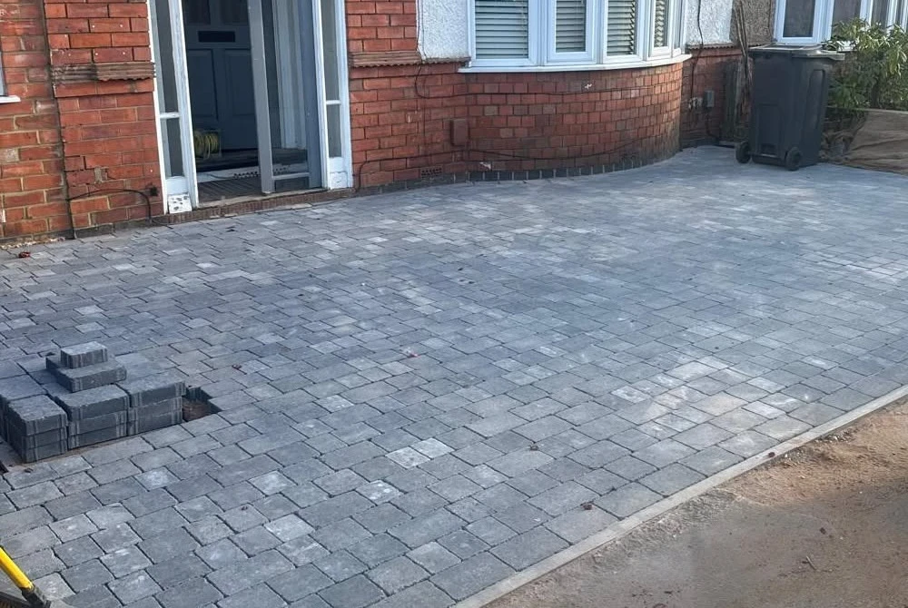 Finished grey block-paved driveway outside a bay-fronted house by Boothville Services.