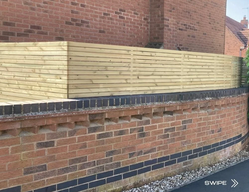 Horizontal timber slats above a brick wall by Boothville Services.