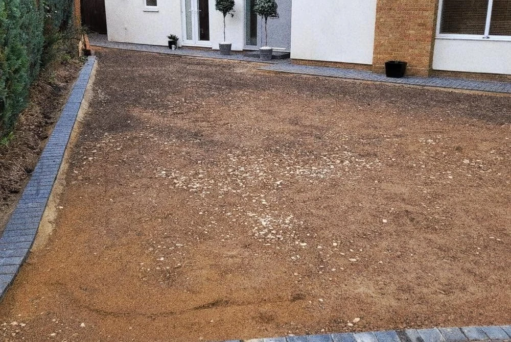 Excavated driveway base outside a white house by Boothville Services.