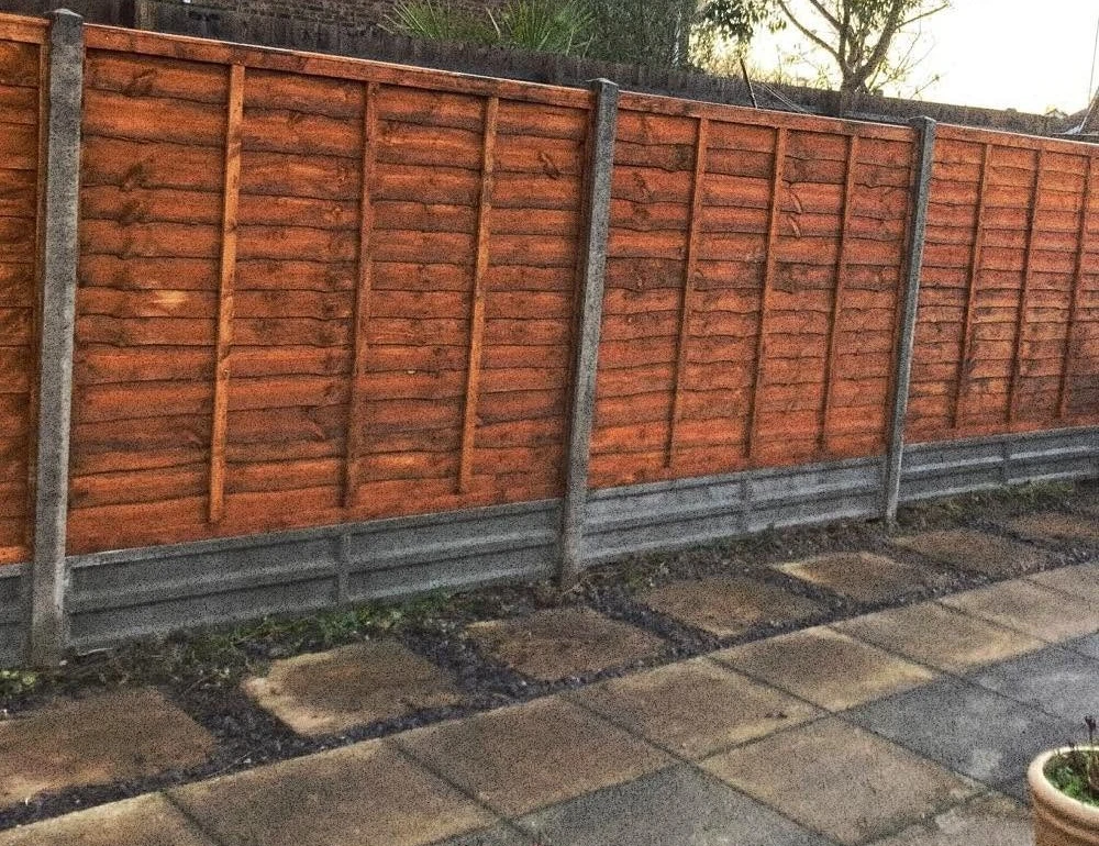 Red timber fence with concrete posts and gravel boards by Boothville Services.
