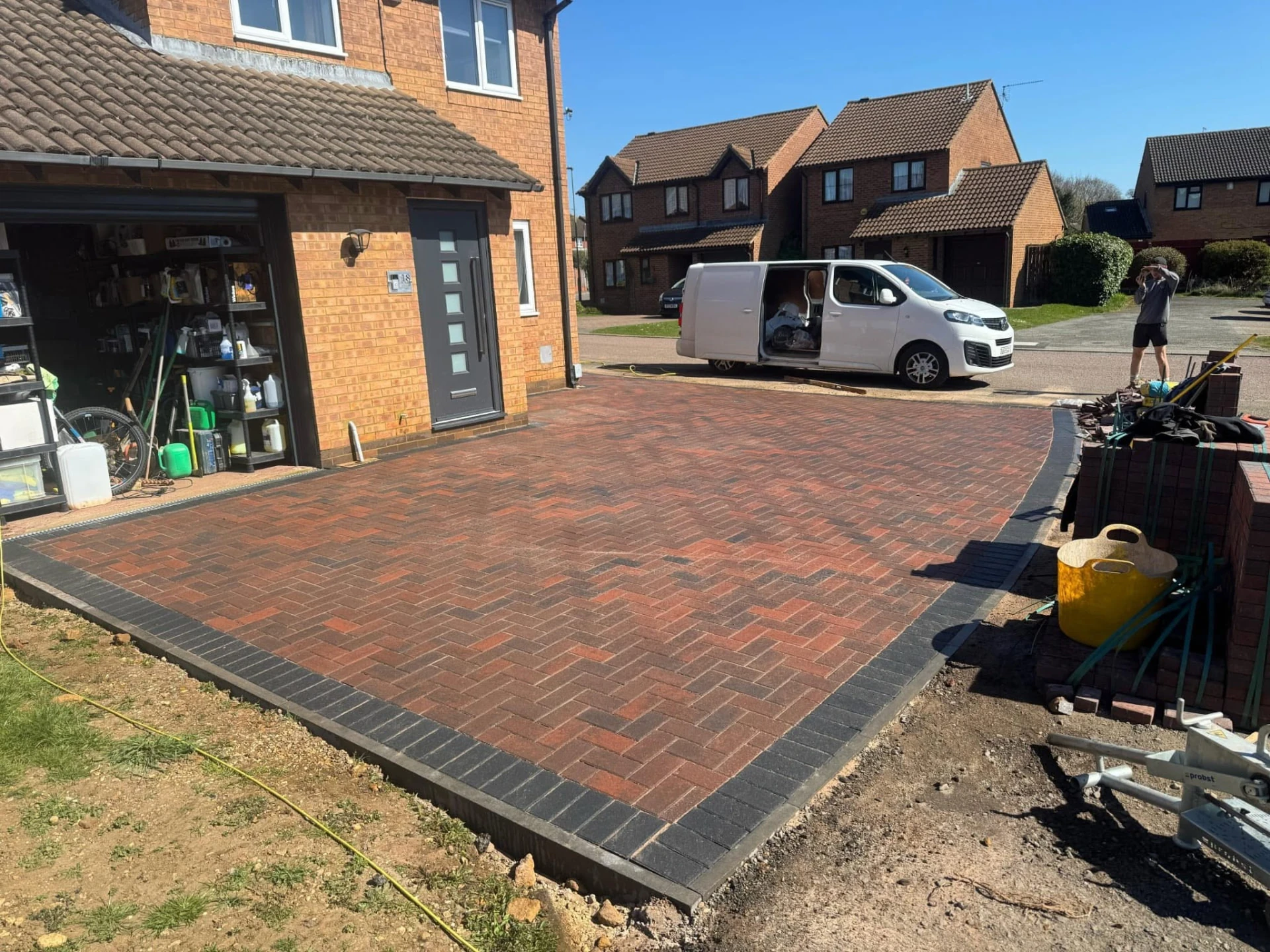 Red block-paved driveway with dark edging by Boothville Services.