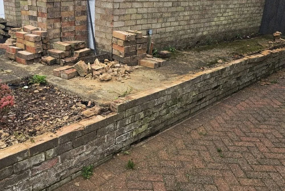 Deteriorated brick wall before rebuilding by Boothville Services.